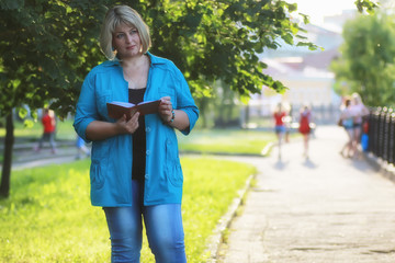 Obraz premium woman in the park green tree with book