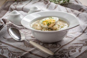 Sorrel soup with egg in white bowl.