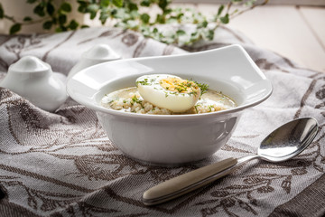 Sorrel soup with egg in white bowl.