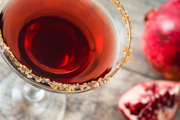 Pomegranate margarita cocktail on rustic wooden background

