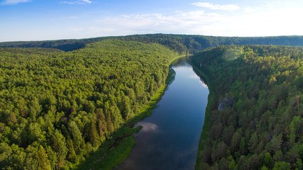 Fototapeta na wymiar endless forest, bend calm river in clear day aerial view