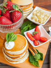 pancakes on a wooden table with berries and fruits