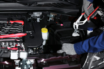 Professional auto mechanic working in repairing service, close-up. Car diagnostics concept