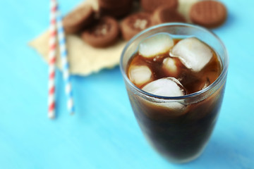 Glass of iced coffee on blue background