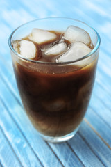 Glass of iced coffee on wooden background
