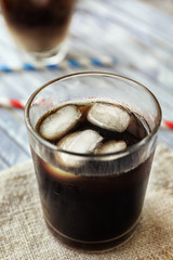 Glass of iced coffee on wooden background