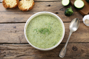 zuppa vellutata di zucchini sfondo tavolo legno rustico