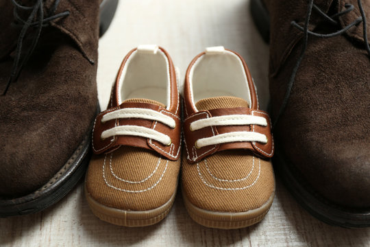 Big and small shoes on wooden floor, closeup