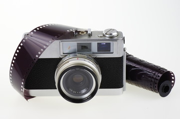 Old rangefinder analog camera system 135 and the photographic film on the white background.