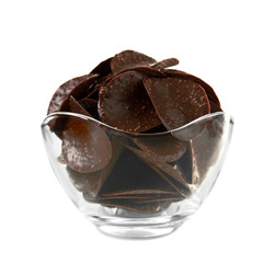 Chocolate chips in glass vase on white background