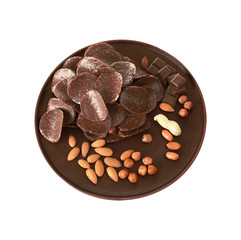 Chocolate chips and different nuts in brown plate on white background