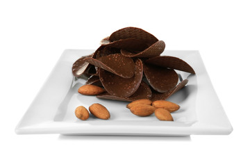 Chocolate chips and almonds in plate on white background