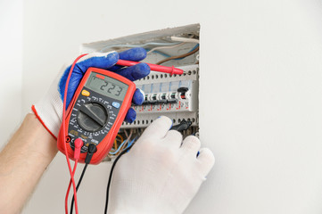 Electrician check voltage in electrical fuse box.