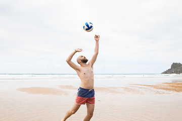 Man playing volley ball in the beach