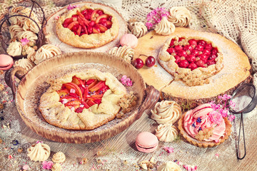 Rustic set of fruit tarts and meringues, homemade pastry, pastel colors.