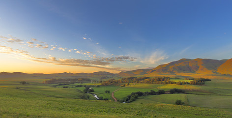 Fototapeta premium Golden Sunrise over the green valley