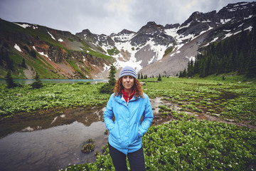 Naklejka premium a portrait of a young woman standing in front of mountains