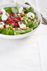salad with beet and cheese served in a white bowl