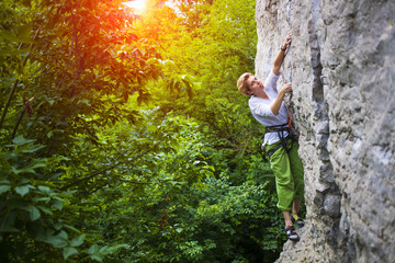 The girl climbs the rock.