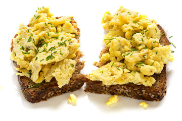 scrambled eggs on rustic wholemeal bread, isolated on a white background