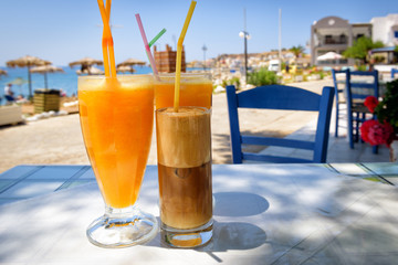 Glasses with orange juice and greek coffee frappe