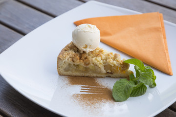 Apple pie dessert decorated with vanilla, mint and cinnamon .