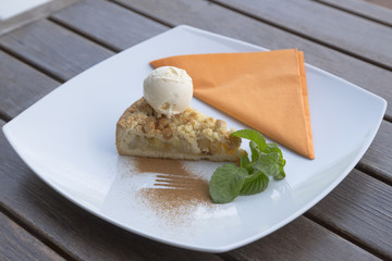 Apple pie dessert decorated with vanilla, mint and cinnamon .