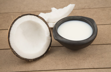 coconut oil and fresh coconuts on old wooden table