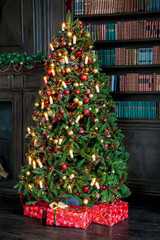 Fototapeta na wymiar Christmas background. Green Classic New Year tree decorated with christmas balls and candles