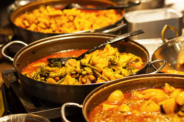 pans with vegetable stew at a food market