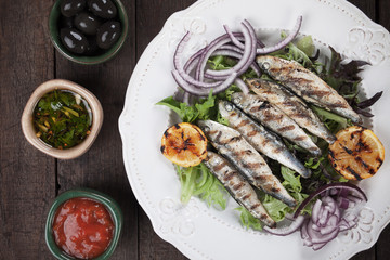 Grilled sardine fish with lettuce and onion