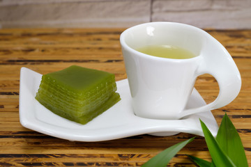 Multi layer sweet cake with hot green tea.