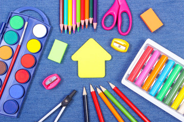 School supplies and shape of building on jeans background, back to school concept