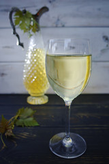 White wine in glass and antique wine pitcher