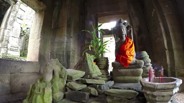 Smoke from incense drifts through an ancient hall before a sacred altar in Bayon Temple, an important historical site in Cambodia. UltraHD video