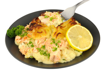 Portion of crispy potato topped fish pie on a black plate