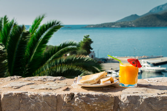 Breakfast of orange juice and toast with sea views.
