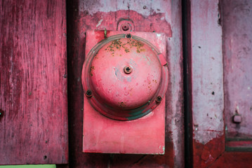 Vintage red bell alarm on red wood wall