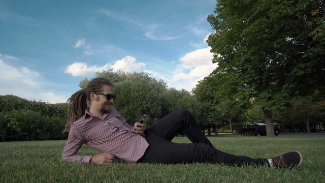 makes selfie in a public park: smart phone, photo