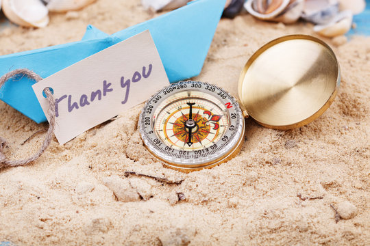 compass in the sand with sign - Thank you