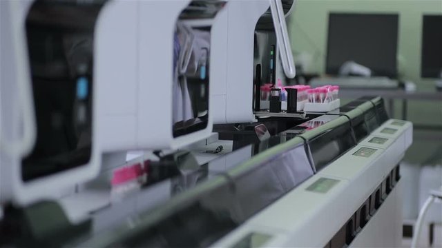 Modern automatic medical hematology analyzer. Test tubes on robotic conveyor. 1080p.