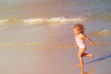 happy child running and jumping in the waves at beach