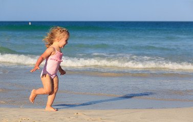 happy child running and jumping in the waves at beach