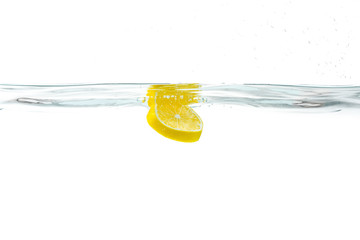 Fresh lemon dropped into water with splash isolated on white