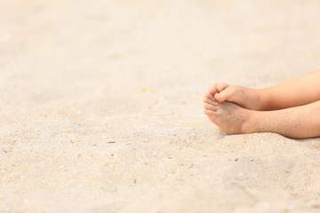 child feet in sand at summer beach