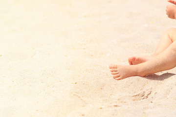 child feet in sand at summer beach