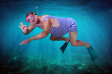 diver in retro swimsuit shows gesture O.K. under water © milkovasa