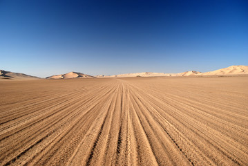 Fototapeta na wymiar Tire tracks sand dunes in desert Oman