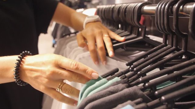 Shopping Female Hands Choosing Clothes in Clothing Store