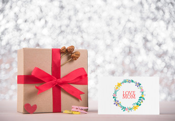 Picture of gift box with red ribbon and message love mom 